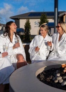 Three woman sat around the outdoor fire pit