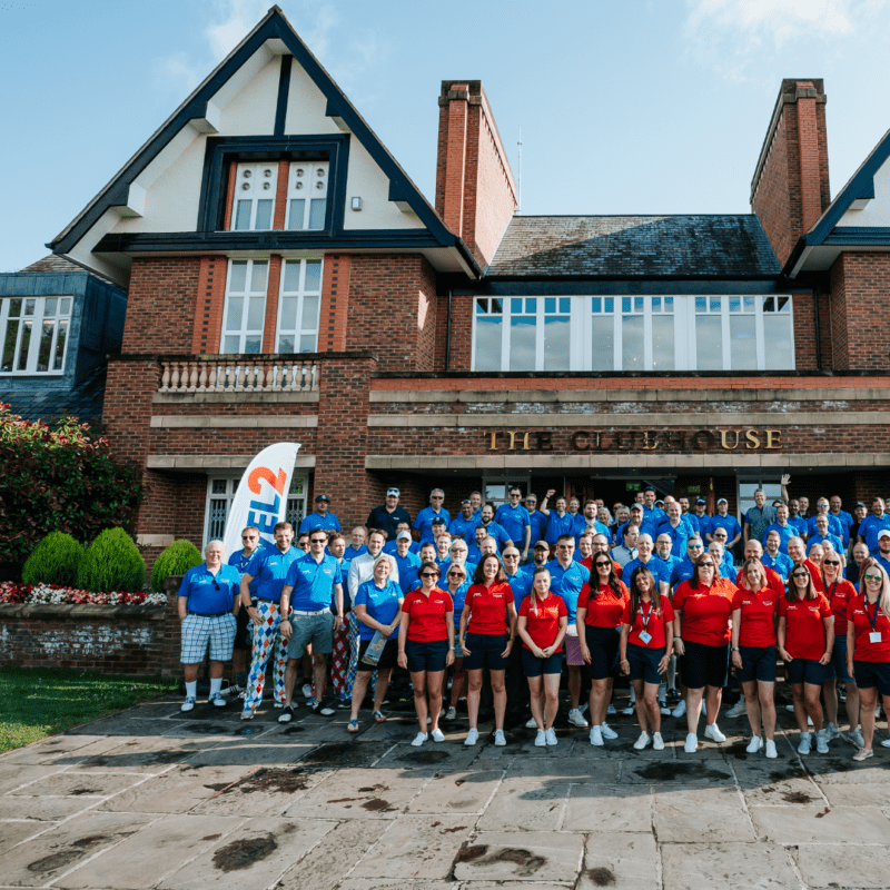 A group of people after playing golf outside the clubhouse